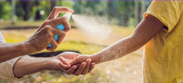 arm getting sprayed with mosquito spray